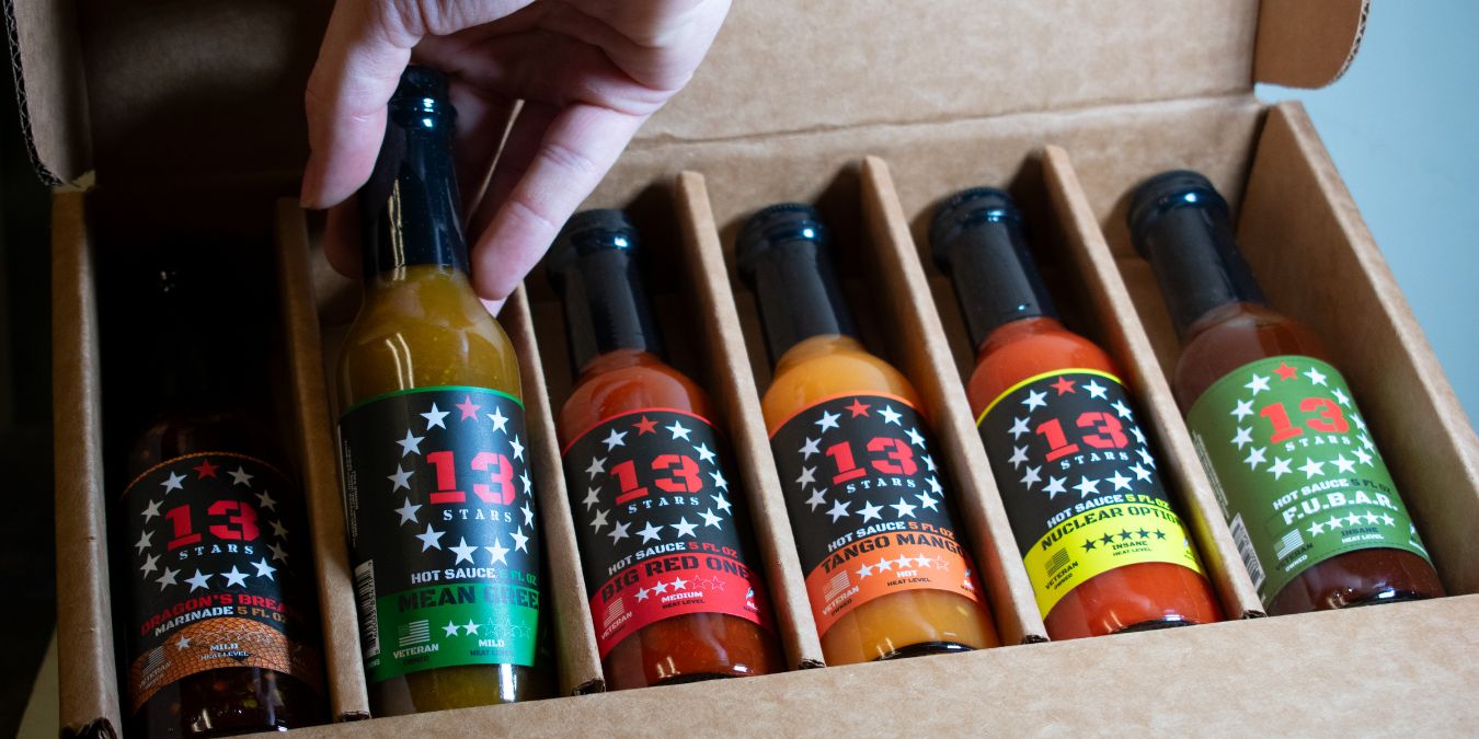 13 Stars Hot Sauce Build Your Own Bundle with a hand placing a bottle of Mean Green