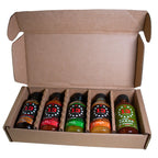 An open brown cardboard gift box containing five small bottles of hot sauce arranged in a divided tray. The bottles have black caps and colorful labels, with the brand number 13 visible on each.