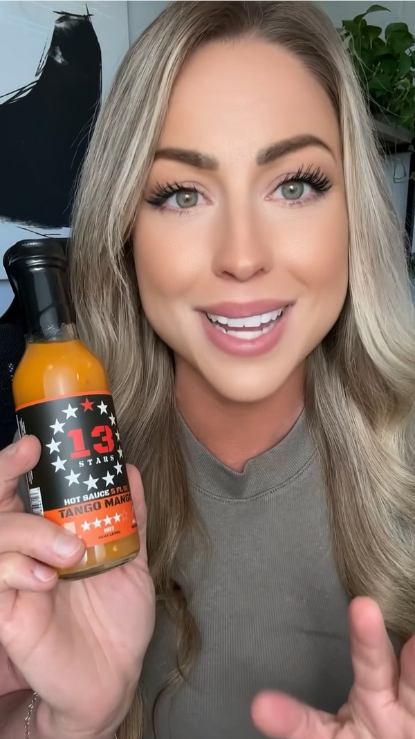 Woman holding a bottle of 13 Star Hot Sauce